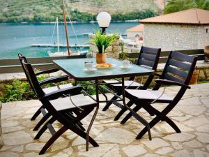 a table and chairs on a patio with a view of the water at Sofia's House in Sivota