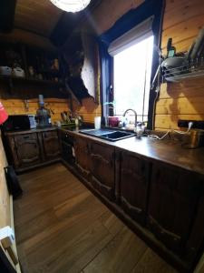 a kitchen with wooden cabinets and a sink and a window at Карпатский Рай in Yaremche
