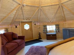 uma sala de estar com um sofá num chalé de madeira em Woodland Lodge Oxen Craig em Kintore