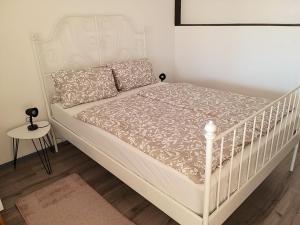 un letto bianco in una camera da letto con una culla bianca di APPART SOMA a Frauenkirchen