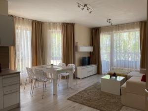 ヴァルナ・シティにあるDeluxe Apartment Varna South Bay Beach Residenceのリビングルーム(白いテーブル、椅子、ソファ付)