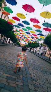 una niñita caminando bajo un montón de sombrillas en Pensiunea Lms, en Brăila