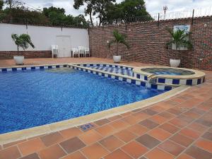 una piscina con acqua blu in un edificio di mattoni di Hotel Fenix a Cúcuta