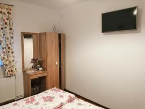 シビウにあるApartament Aimaのベッドルーム1室(壁に薄型テレビ付)