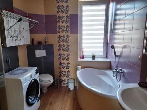 a bathroom with a washing machine and a sink at Tu się śpi in Bodzentyn