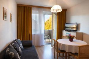 a living room with a couch and a table and a television at Appartements Kanauf in Krumpendorf am Wörthersee