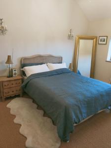 1 dormitorio con 1 cama grande y espejo en Coed Canol Farm, en Abergavenny