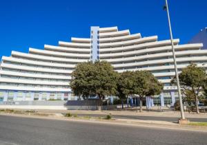 a large white building with trees in front of it at Praia da Rocha Apartments in Portimão