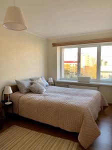 1 dormitorio con cama y ventana grande en klusums 2 en Liepāja