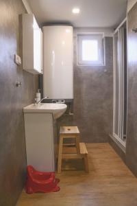 a small bathroom with a sink and a stool at Chata Aktiv in Velké Losiny