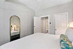 een witte slaapkamer met een groot bed en een spiegel bij 1BR Intimate Apt in Lakeview close to Everything - Oakdale SG in Chicago