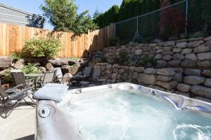 a hot tub in a backyard with a stone wall at Downwider at The Columbia River Gorge in Hood River