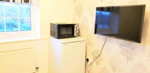 a flat screen tv hanging on a wall at Relaxing En-suite Double Room in Derby