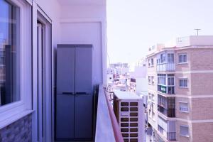 a balcony with a blue door on the side of a building at Cozy House in the City Centre in Málaga