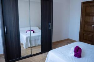 馬拉加的住宿－Cozy House in the City Centre，一间带镜子的卧室和一张带紫色鞋的床