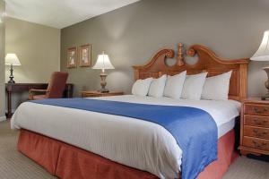 una habitación de hotel con una cama grande y una silla en Club Wyndham Kingsgate, en Williamsburg