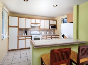 a kitchen with a counter and some chairs in it at Wyndham Mauna Loa Village in Kailua-Kona