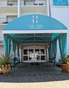 
an outdoor patio area with a large blue umbrella at Inn on Destin Harbor, Ascend Hotel Collection in Destin

