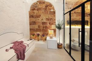 een witte kamer met een bakstenen muur bij Corte Manfredi in Alessano