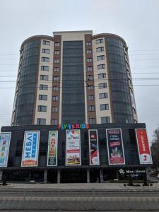 un gran edificio con letreros en la parte delantera en 2 кімнатні ,Люкс апартаменти в ЖК Арена ,район автовокзалу, en Rivne