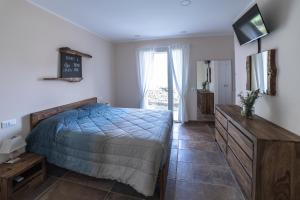 1 dormitorio con 1 cama y TV en Mulino Vigoli, en Morciano di Romagna