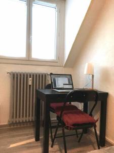 - un ordinateur portable installé sur un bureau dans l'établissement Studio COCONUT, à Chambéry