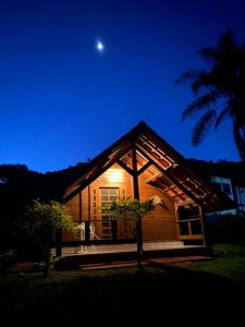 uma casa à noite com a lua no céu em Pousada Gota de Minas em Santo Antônio do Leite
