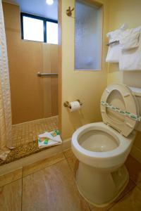 a bathroom with a toilet and a shower with a window at La Costa Beach Club by Capital Vacations in Pompano Beach