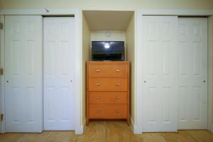a bedroom with two white doors and a dresser at La Costa Beach Club by Capital Vacations in Pompano Beach