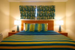 1 dormitorio con 1 cama con 2 lámparas en La Costa Beach Club by Capital Vacations, en Pompano Beach