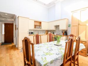 a kitchen with a table and chairs in a room at Courtyard Cottage in Letham