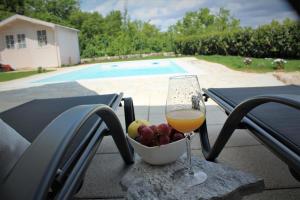 un bicchiere di vino seduto su un tavolo con un cesto di frutta di Villa Lente a Polje