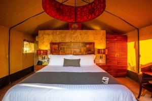 1 dormitorio con 1 cama grande en una tienda de campaña en Serenity Authentic Glamping Tulum en Xpu Ha