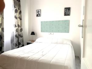 ein weißes Schlafzimmer mit einem weißen Bett und einem Fenster in der Unterkunft Apartamentos JS Playa in Finestrat