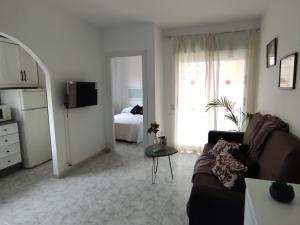 ein Wohnzimmer mit Sofa und ein Schlafzimmer in der Unterkunft Apartamentos JS Playa in Finestrat