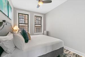 a white bedroom with a bed and two windows at Relaxing 1BR Apt in Lakeview near Best Restaurants - Belmont H6 in Chicago