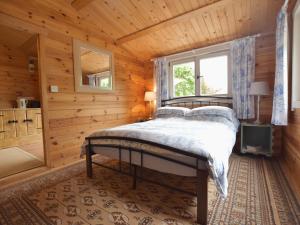 a bedroom with a bed in a wooden cabin at Mill Cabin Denant in Haverfordwest