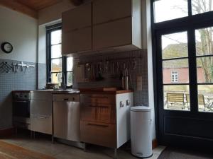 una cucina con elettrodomestici in acciaio inossidabile e una grande finestra di Villa Nikolaj - Historisches Pastorat a Fehmarn