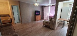 a living room with a tv and a couch and chairs at КВАРТИРА 2 КОМНАТЫ 45м in Koltsovo