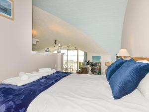 a bedroom with a large bed with blue pillows at Cannons Folly in Torpoint