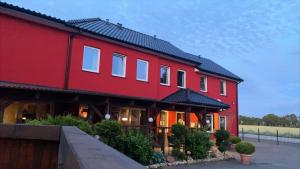 a red building with a black roof at Der Tanzhase in Hasenmoor