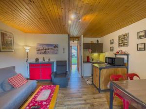 a living room with a couch and a kitchen at Appartement 'Les Airelles du Lac' T2 Gérardmer in Gérardmer