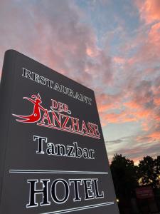 een bord voor een hotel met een zonsondergang op de achtergrond bij Der Tanzhase in Hasenmoor