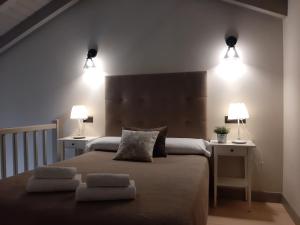a bedroom with a large bed with two lights on it at Apartamentos El Llanin in Cangas de Onís