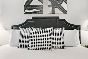 uma cama com almofadas pretas e brancas em Convenient 1BR Apt in Lakeview near Shops - Oakdale 204 em Chicago