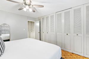 um quarto branco com uma cama e uma ventoinha de tecto em Convenient 1BR Apt in Lakeview near Shops - Oakdale 204 em Chicago