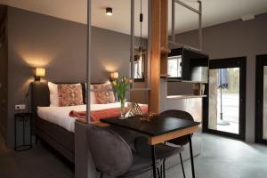 1 dormitorio con cama, mesa y comedor en Adelaerthoeve Logies & Ontbijt, en Arnhem