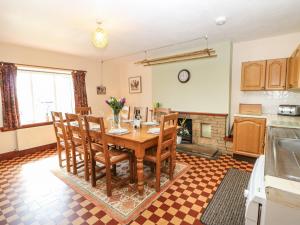 a kitchen with a table and chairs in a room at Sunnyside Cottage in Stainton