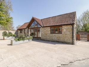 uma casa de pedra com uma grande entrada em The Stone Barn em Shepton Mallet