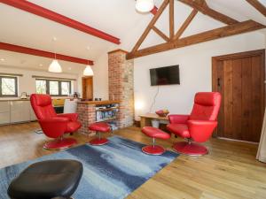 a living room with red chairs and a blue rug at The Stone Barn in Shepton Mallet